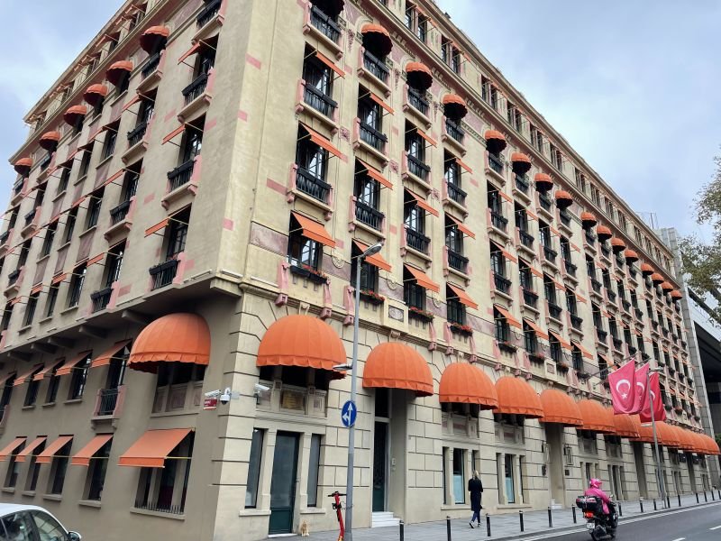A grand stone apartment building with iron balconies and orange awnings in Nişantaşı